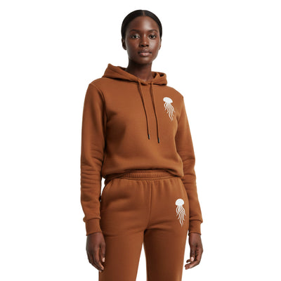 A woman wearing a brown hoodie and pants with a jellyfish logo on a white background