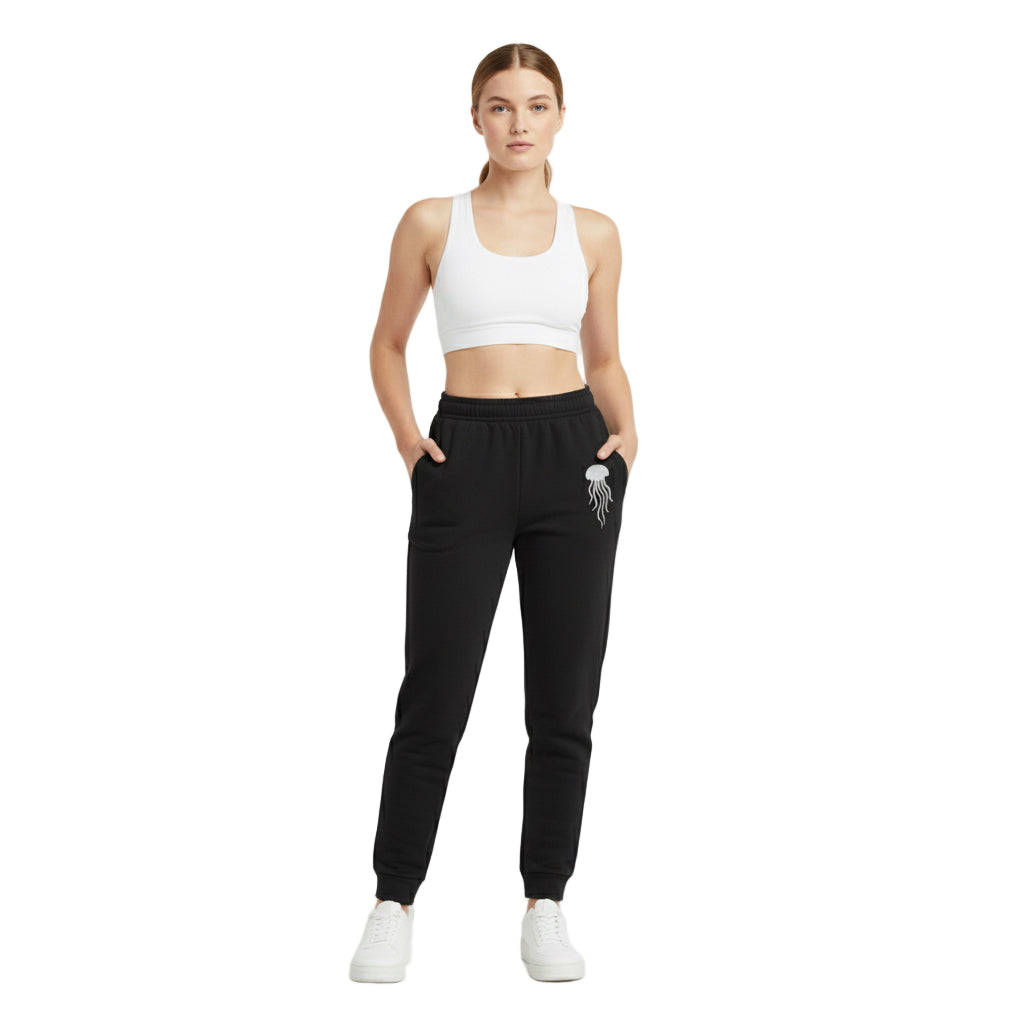 Woman wearing a white sports bra and black jogger pants on a white background
