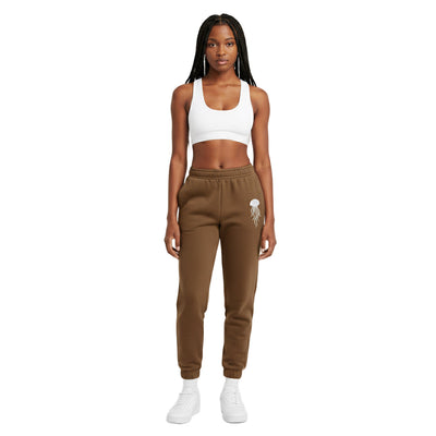 Woman wearing brown sweatpants with a small white design on a white background