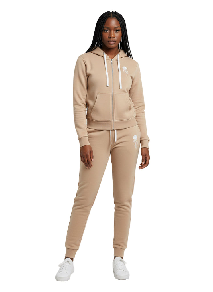 A woman wearing a beige tracksuit with a brand logo on a white background